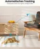 A cat is lying on the floor, and another cat is sitting on a chair, with a dotted line indicating movement between them, suggesting automatic tracking. Produktbild-Vorschau