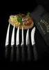 A set of six knives arranged in front of a wooden cutting board with cheese, cured meat, and peppers, with a black carrying case in the background. Náhľad obrázku produktu