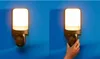 A hand is shown interacting with a WiZ outdoor wall light that has a built-in camera. Produktbild-Vorschau