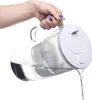 A hand is pouring water from a glass pitcher. Náhled obrázku produktu