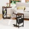 Two C-shaped side tables with a rustic wood top and black metal frame are placed next to a white sofa in a living room setting. Voir les images du produit