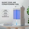 A white air conditioning fan with blue lighting sits on a table next to some books. A green plant is visible in the background. Produktbild-Vorschau