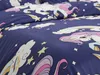 A close-up view of a navy blue duvet cover with a unicorn and rainbow pattern. Produktbild-Vorschau