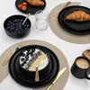 A breakfast setting with plates, bowls, croissants, blueberries, yogurt, and coffee. Voir les images du produit
