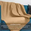 A beige fleece blanket draped over a blue sofa. Náhľad obrázku produktu