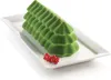 A green, tree-shaped silicone mold on a white rectangular plate, garnished with red currants. Produktbild-Vorschau