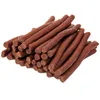 A pile of brown, stick-shaped dog treats on a white background. Produktbild-Vorschau