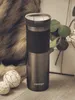 A Contigo travel mug is displayed on a wooden surface with decorative balls and greenery in the background. Anteprima dell’immagine prodotto