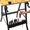 A workbench with tools is shown, with a hand reaching for a screwdriver. Náhled obrázku produktu