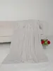 A light gray microfiber blanket is draped over a sofa, with a small vase of red roses and greenery in the foreground. Produktbild-Vorschau