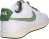 A side view of a white Nike sneaker with green accents. Produktbild-Vorschau