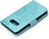 A teal flip phone case with a mandala pattern embossed on the cover, shown from a diagonal top-down perspective. Produktbild-Vorschau