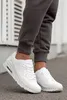 A person wearing white sneakers and gray sweatpants. Produktbild-Vorschau