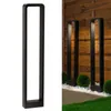 A black, modern, rectangular outdoor lamp post is shown against a white background on the left, and two similar lamps are shown in a garden setting on the right. Produktbild-Vorschau