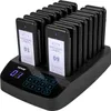 A black restaurant pager system with multiple pagers docked in a charging base, displayed on a black surface. Produktbild-Vorschau