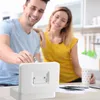 A couple is in a kitchen, with the man putting money into a white cash box. Produktbild-Vorschau