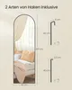 A full-length arched mirror is shown leaning against a wall, with a bed and pillows in the reflection. Diagrams of two types of hooks with dimensions are shown to the right of the mirror. Produktbild-Vorschau