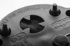 A close-up, black and white shot of the underside of a black plastic device, likely an air pump, showing some text and a circular grate with a filter. Podgląd zdjęcia produktu