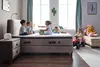 Children playing on and around a bed in a bedroom setting. Produktbild-Vorschau