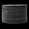 A stack of black weight plates against a black background. Produktbild-Vorschau