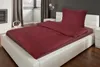 A bedroom scene with a bed made with burgundy seersucker bedding. Produktbild-Vorschau