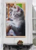 A framed picture of a kitten hanging on a wall above a table. Produktbild-Vorschau