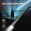 A person in a hat shines a powerful LED flashlight in a dark, outdoor setting. Produktbild-Vorschau