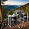 A camping kitchen set up outdoors with a scenic mountain and forest view in the background. Produktbild-Vorschau