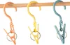 Three colorful clothes pegs with hooks hanging on a wooden rod. Anteprima dell’immagine prodotto