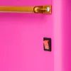 Close-up of a pink surface with a gold bar attached by a silver screw, and a red switch in a black housing. Produktbild-Vorschau