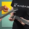 A person wearing a black t-shirt with a logo is holding a spiked bird deterrent strip. Another hand is shown cutting the strip with orange-handled scissors. Náhľad obrázku produktu