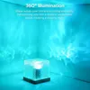 A cube-shaped lamp with a textured, clear surface sits on a surface, projecting a blue, wavy light pattern onto the walls and ceiling of a room. Produktbild-Vorschau