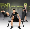Three men are shown in different workout poses with a weight bench and dumbbells. The word "Plank" is prominently displayed in neon yellow text in the background. Náhľad obrázku produktu