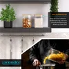 A kitchen scene with storage jars on a shelf and someone pouring pasta into a pot. Podgląd zdjęcia produktu