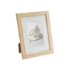 A wooden picture frame with a white mat and a picture of a small lantern on a wooden background. Produktbild-Vorschau