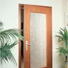 A wooden door with a frosted glass panel is shown slightly ajar, with plants on either side. Produktbild-Vorschau