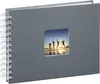 A gray spiral-bound photo album with a square window on the cover showing a picture of four people jumping in the air by the water at sunset. Produktbild-Vorschau