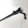 A close-up shot of a black adjustable curtain rod mounted on a light-colored wall. Produktbild-Vorschau