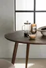 A dark brown round dining table with a French press, a candle, and a cup of coffee on it. Produktbild-Vorschau