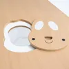 A close-up view of a wooden children's table with a hole and a lid shaped like a bunny's face. Produktbild-Vorschau