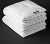 A stack of white duvets on a black background. Produktbild-Vorschau