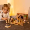 A young child plays with a wooden nativity scene set on a textured surface. Produktbild-Vorschau