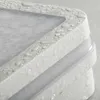 A close-up view of a white, textured light fixture with water droplets on its surface. Náhľad obrázku produktu
