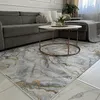 A living room scene with a sofa, coffee table, and rug. Produktbild-Vorschau