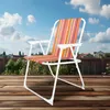 A striped camping chair is set up on a wooden deck outdoors, with a blue sky and clouds in the background. Produktbild-Vorschau