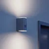 A blue wall-mounted outdoor light fixture emitting light upwards and downwards. Produktbild-Vorschau