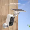 A white security camera and its solar panel are mounted on a wooden wall, with a blue sky in the background. Náhled obrázku produktu