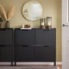 A hallway or living room setting with a shoe cabinet, mirror, and decorative items. Produktbild-Vorschau