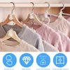 Close-up view of multiple sweaters hanging on wooden and gray hangers on a closet rod. Below the sweaters are circular icons with text. Produktbild-Vorschau