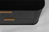 A close-up view of a black cabinet with gold handles, showing its ribbed texture. Produktbild-Vorschau